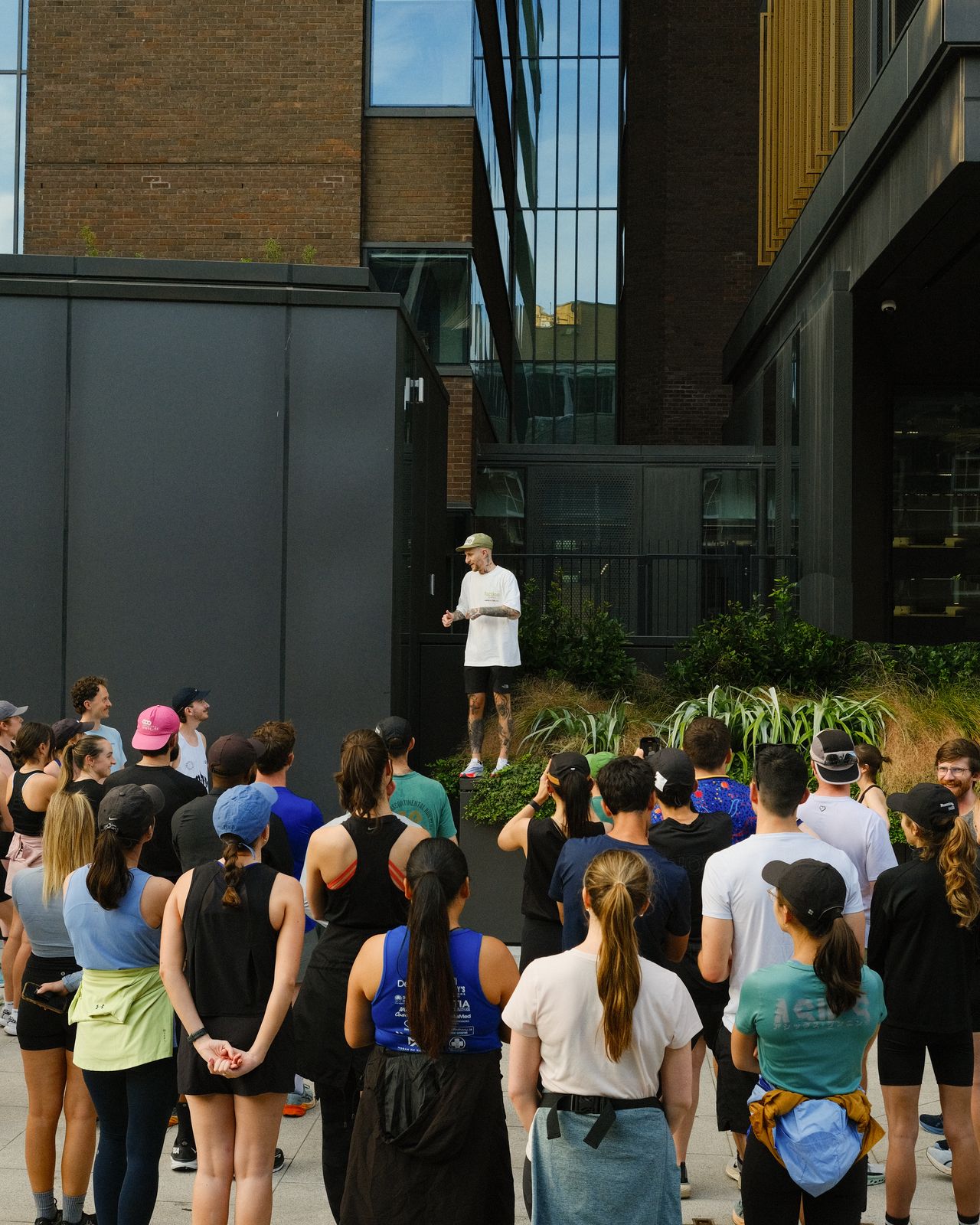 A run leader on a raised step giving the pre-run briefing to a crowd of members.