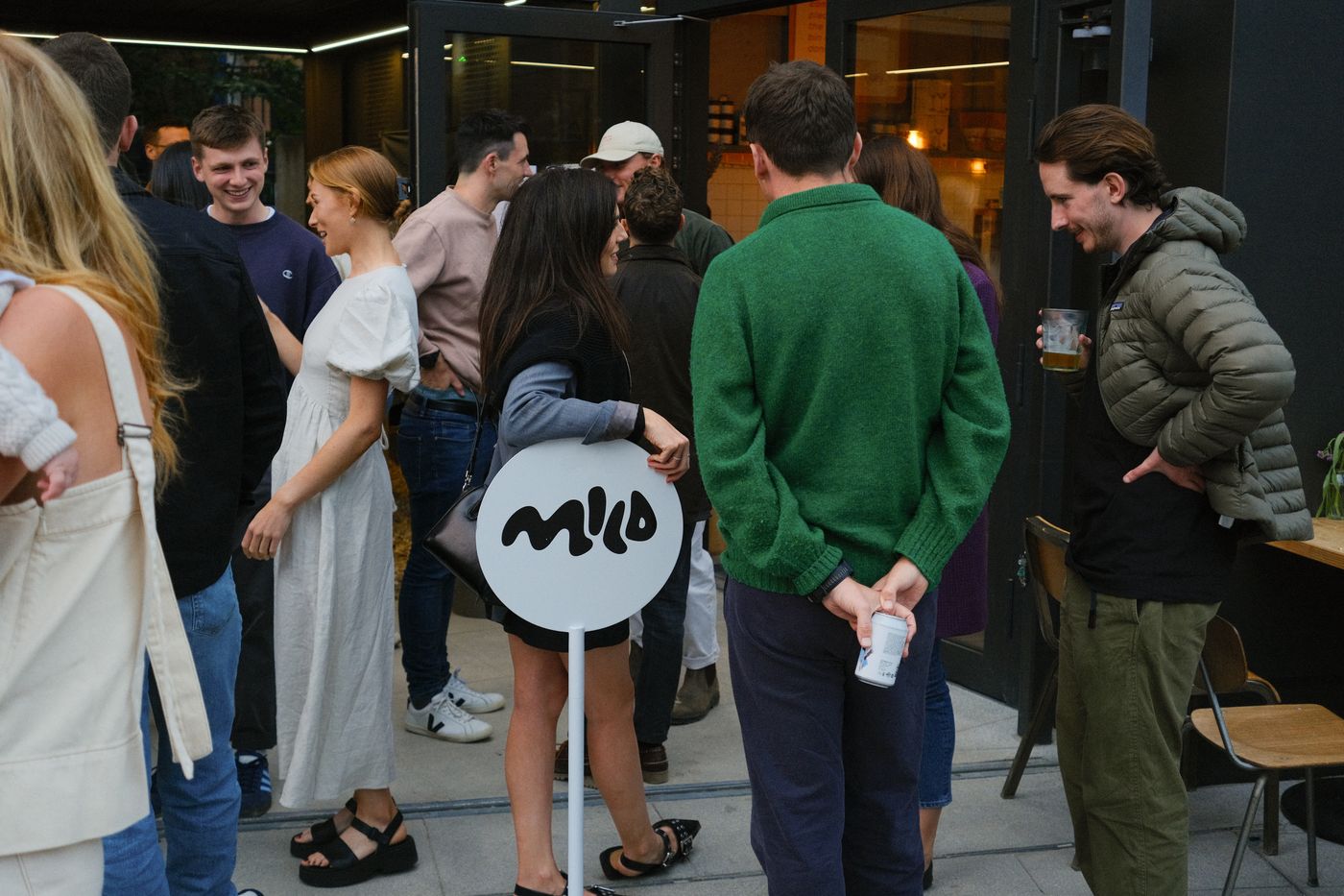 Members chatting outside a restaurant beside a Mild Activity sign.